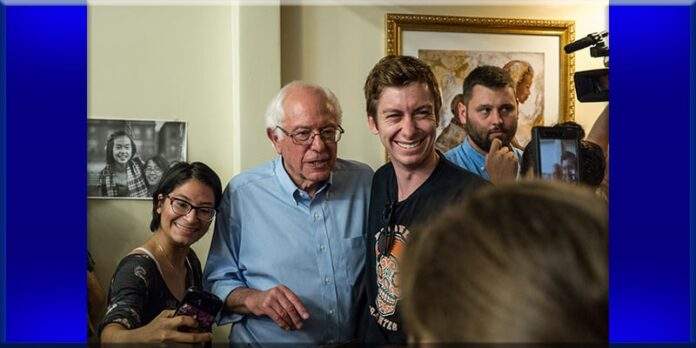 Bernie Sanders standing with supporters his campaign staff